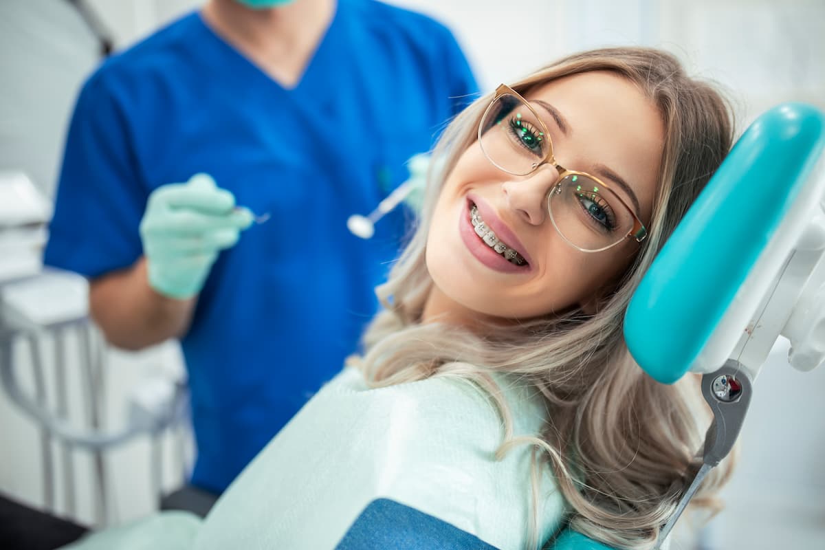 Patiente portant des broches métalliques, illustrant un traitement orthodontique classique pour corriger l'alignement des dents.